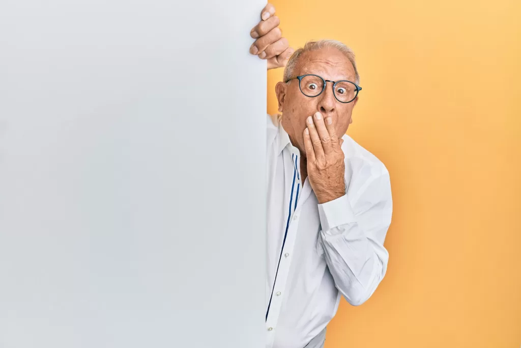 A man peeking out from behind a wall, looking surprised